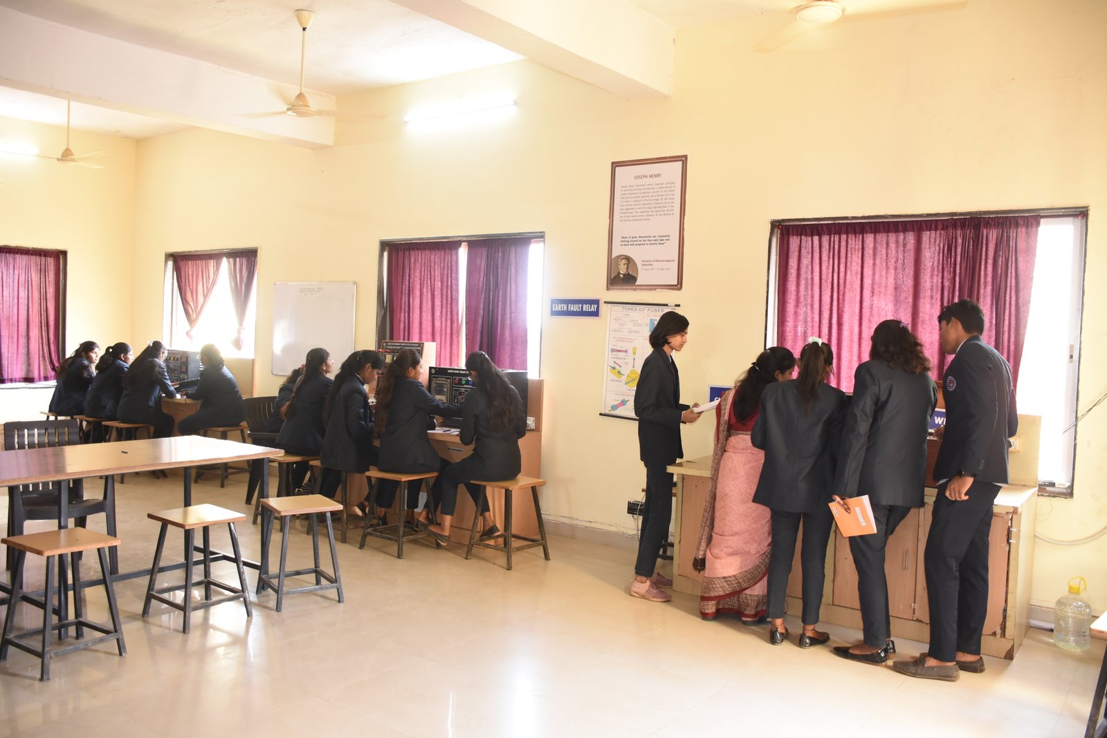 Rear view of mature teacher talking to his student during lecture at university classroom.